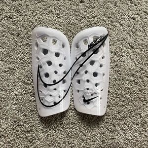 White Nike shinguards size large.